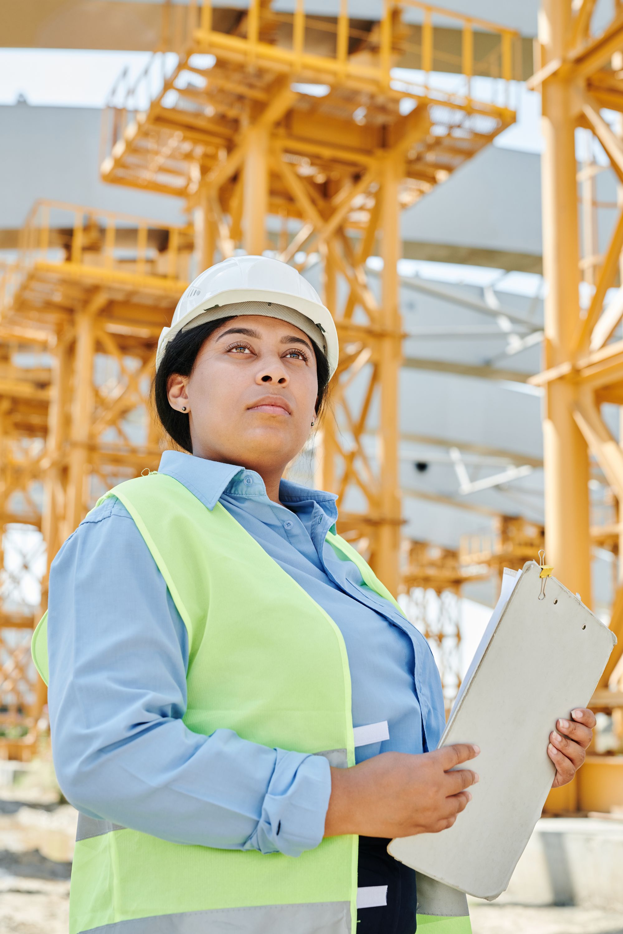 Lavoratrice con elmetto e dispositivi di protezione in un cantiere